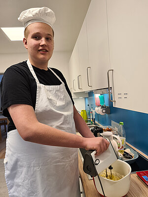 Das Rührgerät brummt. Begeistert bereitet ein Gastkind im KIOLA-Haus Pfannkuchenteig zu. Foto:KIOLA